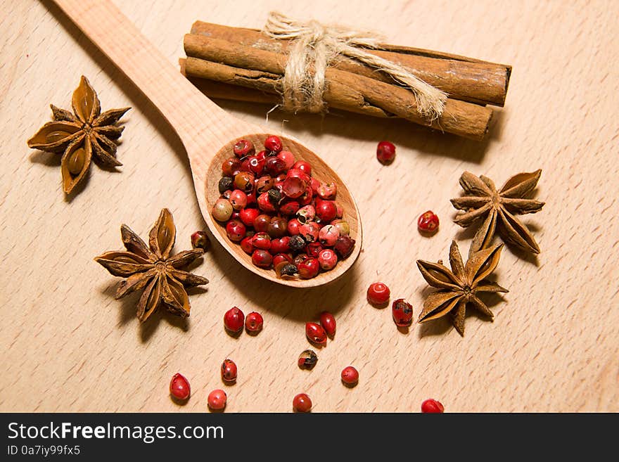 Spoon with a mixture of grains of pepper, cinnamon and star anis