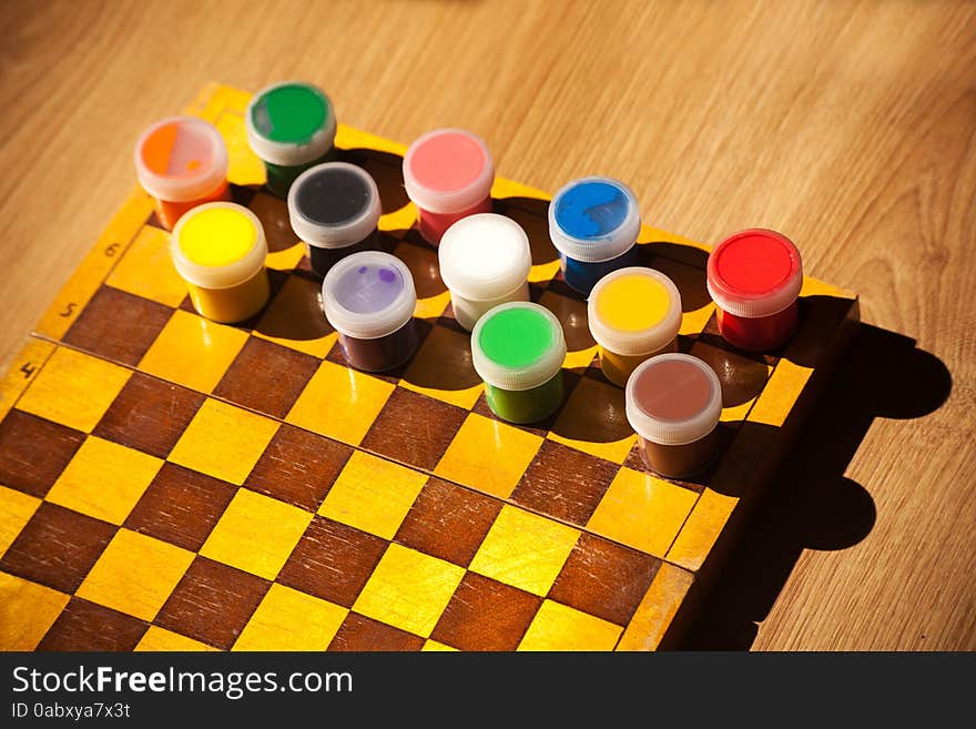 Colourful watercolor paint on the chessboard closeup