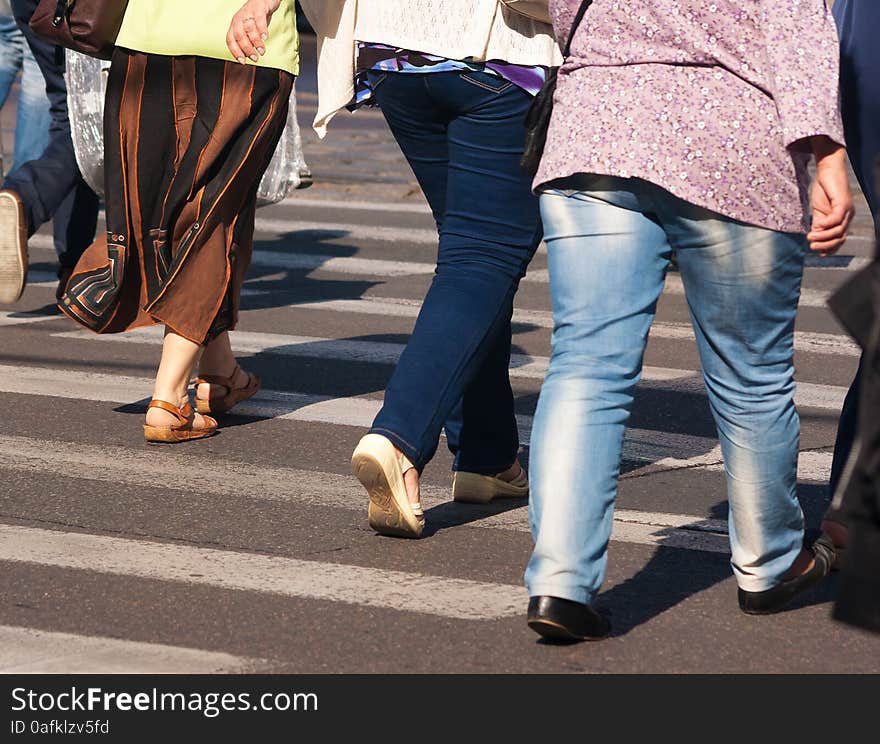 Feet of elderly pedestrians walking on the crosswalk on summer day. Feet of elderly pedestrians walking on the crosswalk on summer day