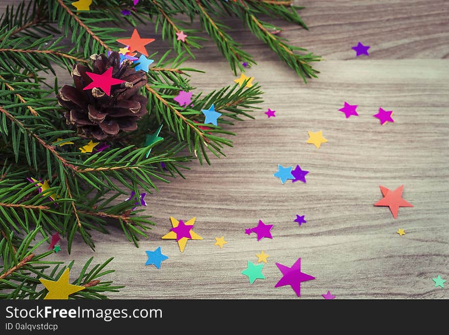 Spruce branches with festive decoration on the wooden background