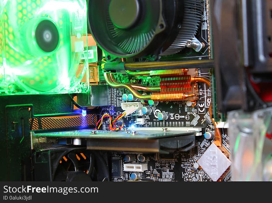 A close up of a computer mainboard with a green fan in the background. A close up of a computer mainboard with a green fan in the background.