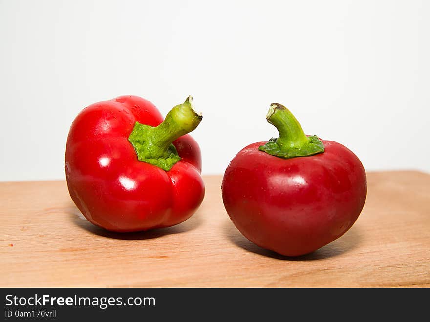 Two Ripe Red Peppers On Over White