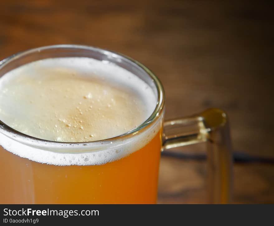 Mug of fresh beer on the table closeup. Mug of fresh beer on the table closeup