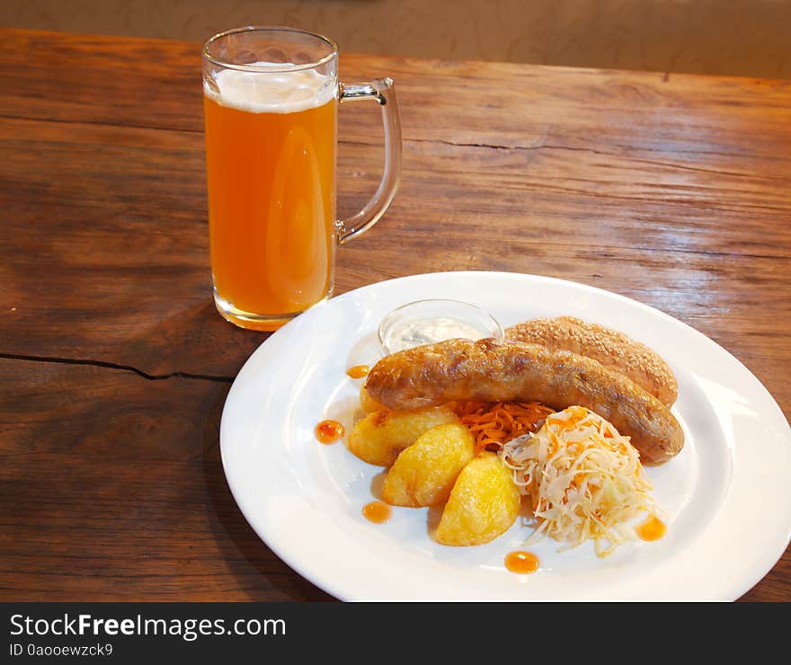 Sausages with vegetables and mug with beer