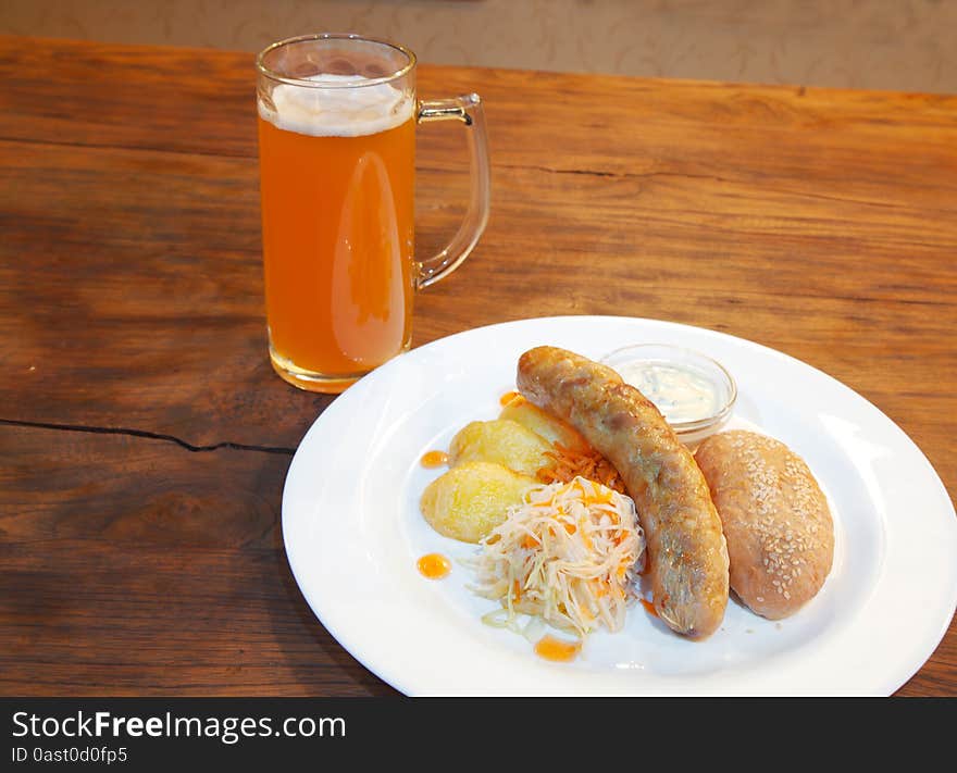 Sausages with vegetables and mug with beer