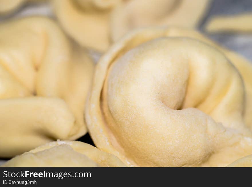 Baking process - raw dumplings with white flour powder particles on a table