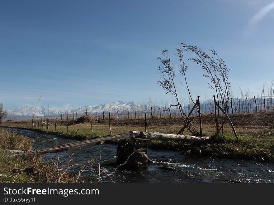 A bridge over a small river in the Talas region of Kyrgyzstan. Mountains in the background. A mountainous and remote region of Kyrgyzstan. A bridge over a small river in the Talas region of Kyrgyzstan. Mountains in the background. A mountainous and remote region of Kyrgyzstan.