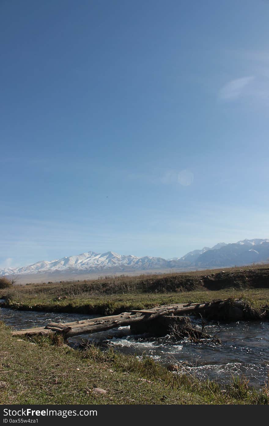 A bridge over a small river in the Talas region of Kyrgyzstan. Mountains in the background. A mountainous and remote region of Kyrgyzstan. A bridge over a small river in the Talas region of Kyrgyzstan. Mountains in the background. A mountainous and remote region of Kyrgyzstan.