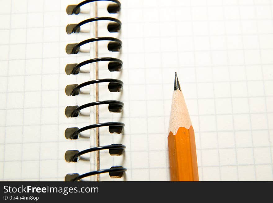 Opened notebook with a blank sheet and pencil on over white. Opened notebook with a blank sheet and pencil on over white