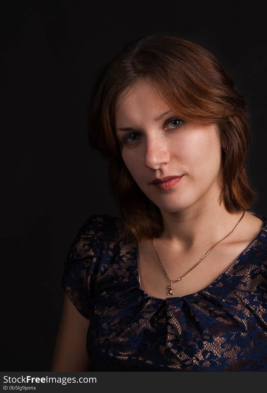 Portrait of a young beautiful girl on a dark background