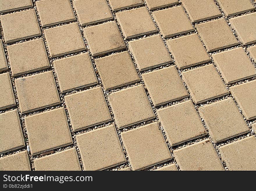 Patterned light brown paving street tiles on the road. Patterned light brown paving street tiles on the road