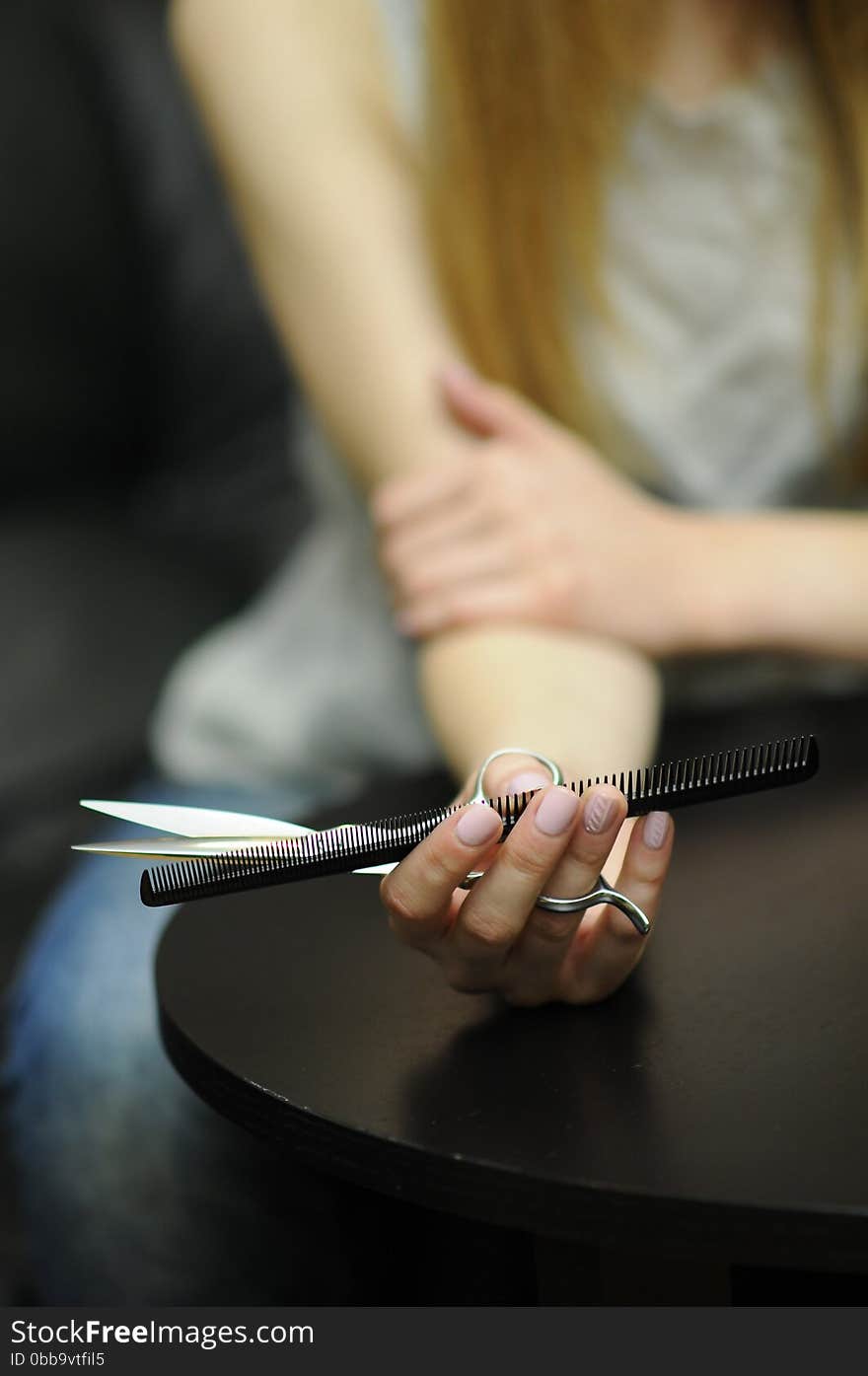 Barber tools in the hands of professional scissors and comb in his hand barber