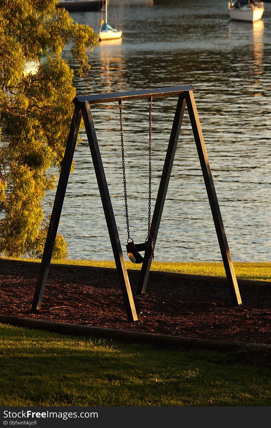 Child's rubber swing in the late afternoon on the shores of Sydney Harbour. Child's rubber swing in the late afternoon on the shores of Sydney Harbour