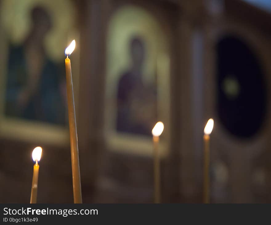 Four bright burning candles in a church