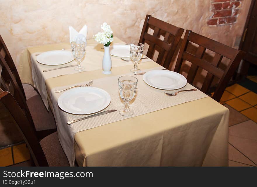 Wineglasses and plates on table in restaurant