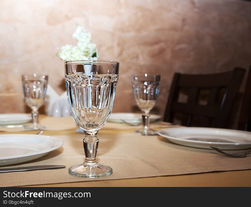 Wineglasses and plates on table in restaurant closeup