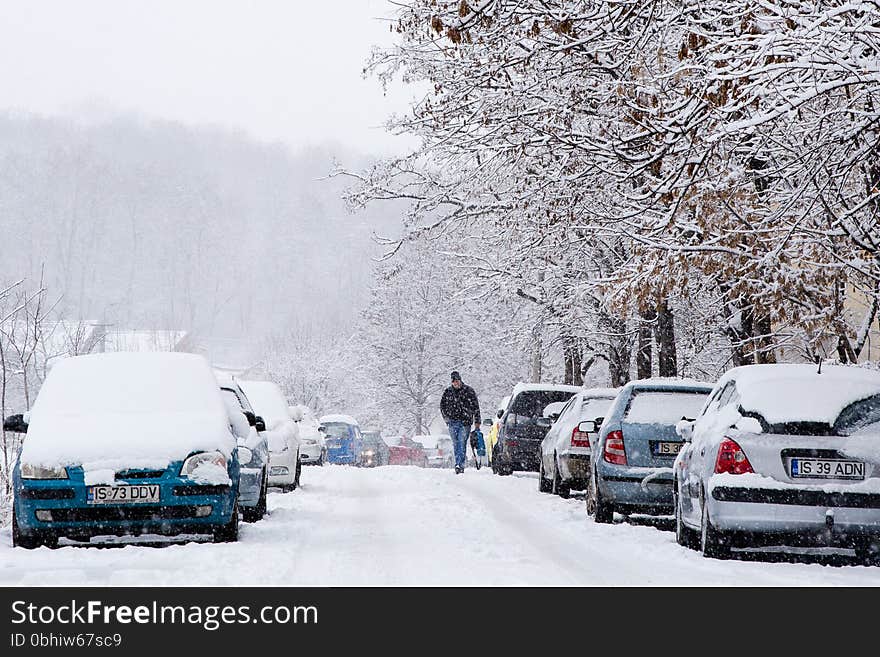 Man walking on a icy road during snowstorm