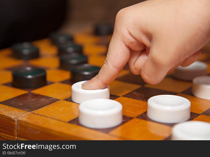 Child's finger moves the piece to the chessboard