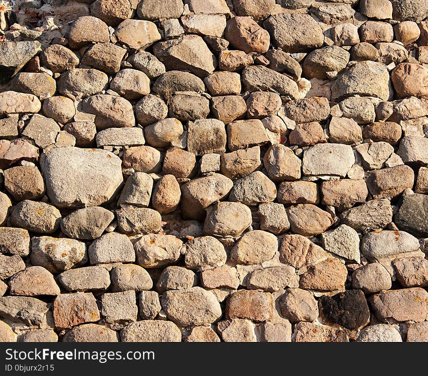 Vintage wall of large stones on sunny day closeup