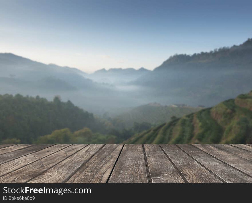 Wooden table and the tea plantations background