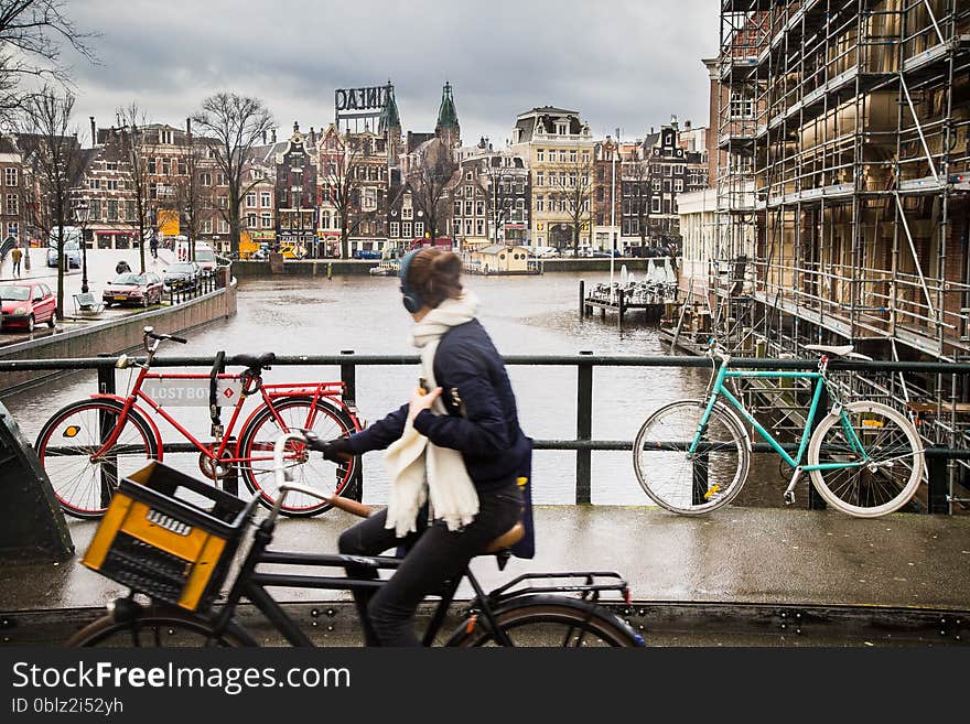 Amsterdam view with a girl on bicycle looking towards a canal.