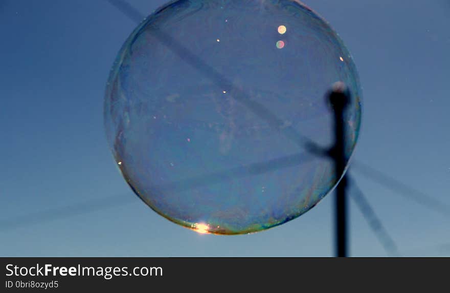 Shimmering bubble cluster with bokeh effect  floating past telephone wires. Shimmering bubble cluster with bokeh effect  floating past telephone wires