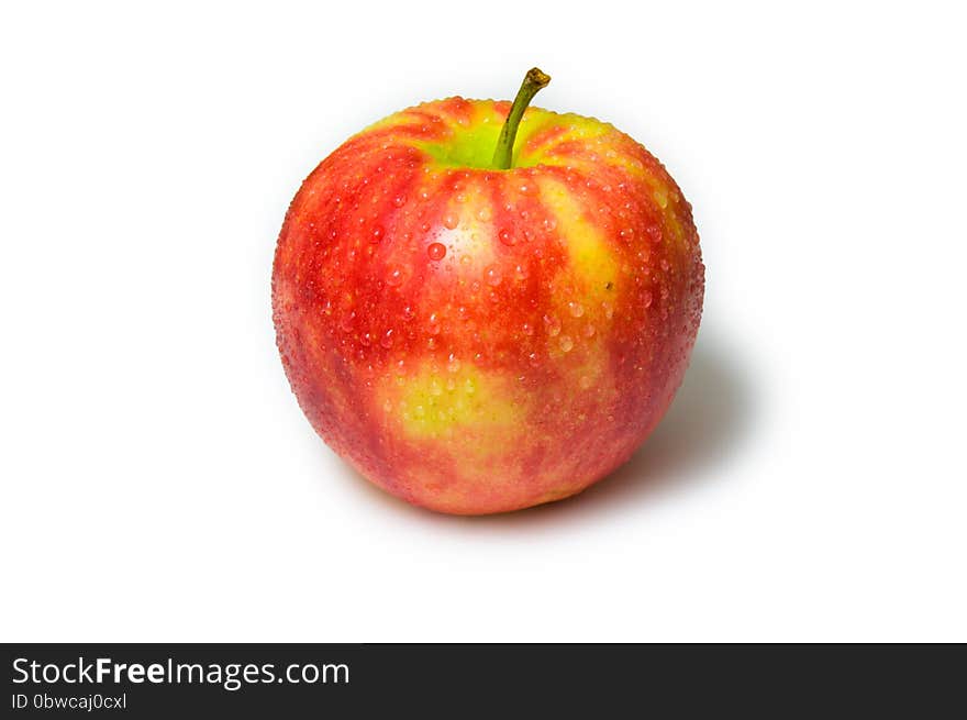 Red apple with water drops on a white background. Red, White, Yellow, colors