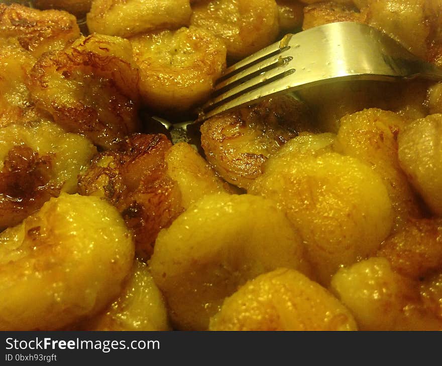 Sliced Bananas Fried In Oil With Fork On Plate.