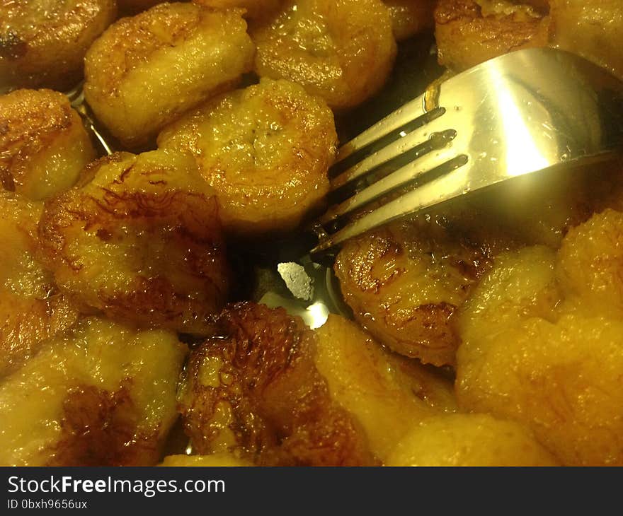 Sliced Bananas Fried in Oil with Fork on Plate.