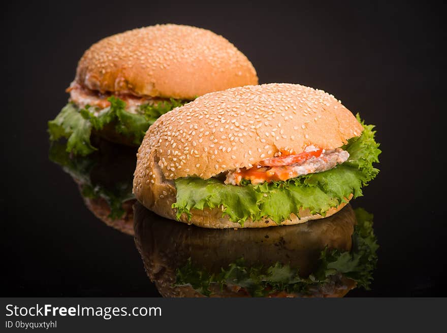 Two delicious hamburger with reflection on the table. Two delicious hamburger with reflection on the table.