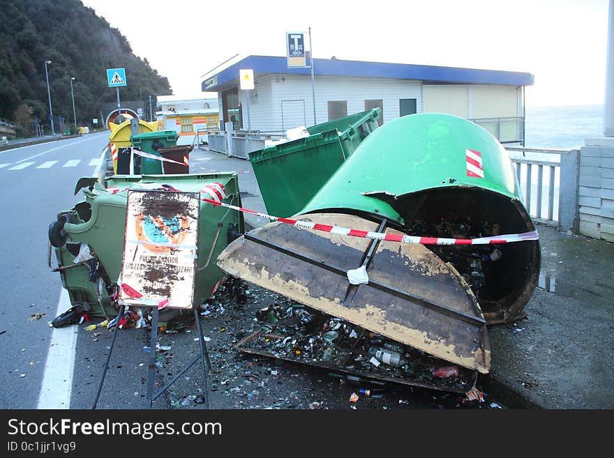 Bins of broken waste with the garbage strewn on the road. Bins of broken waste with the garbage strewn on the road