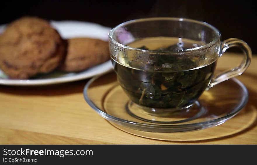 Glass Cup With Tea And Biscuits On A Plate