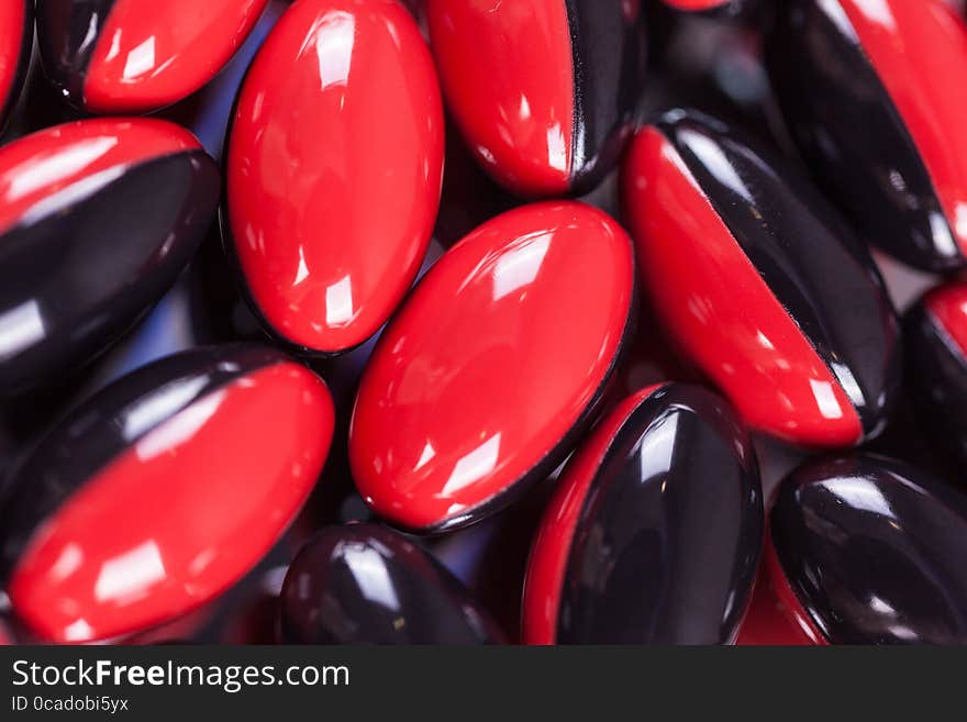 A Scattering Of Red-black Brown Pills On The Mirror Background