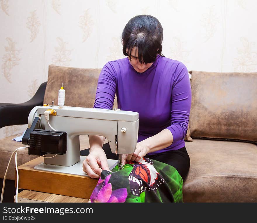 Woman sews on the sewing machine