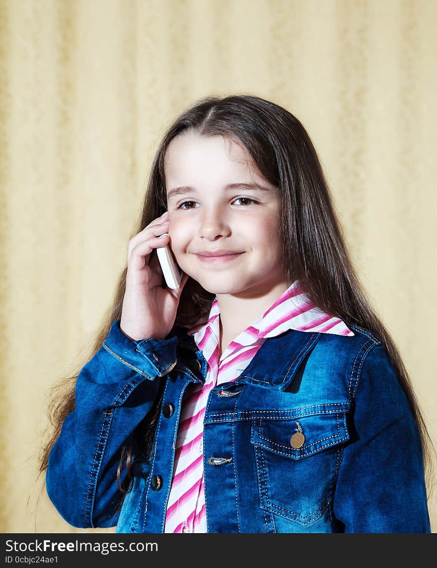 Girl in a blue denim jacket talking on a phone