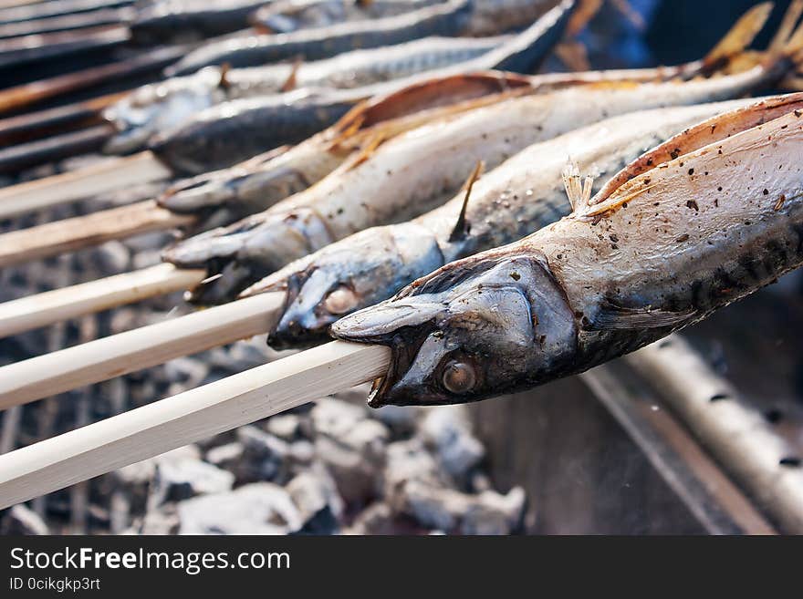 Fish cooking on hot coals outside closeup