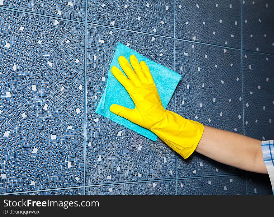 Woman washes a tile in the bathroom, hand closeup