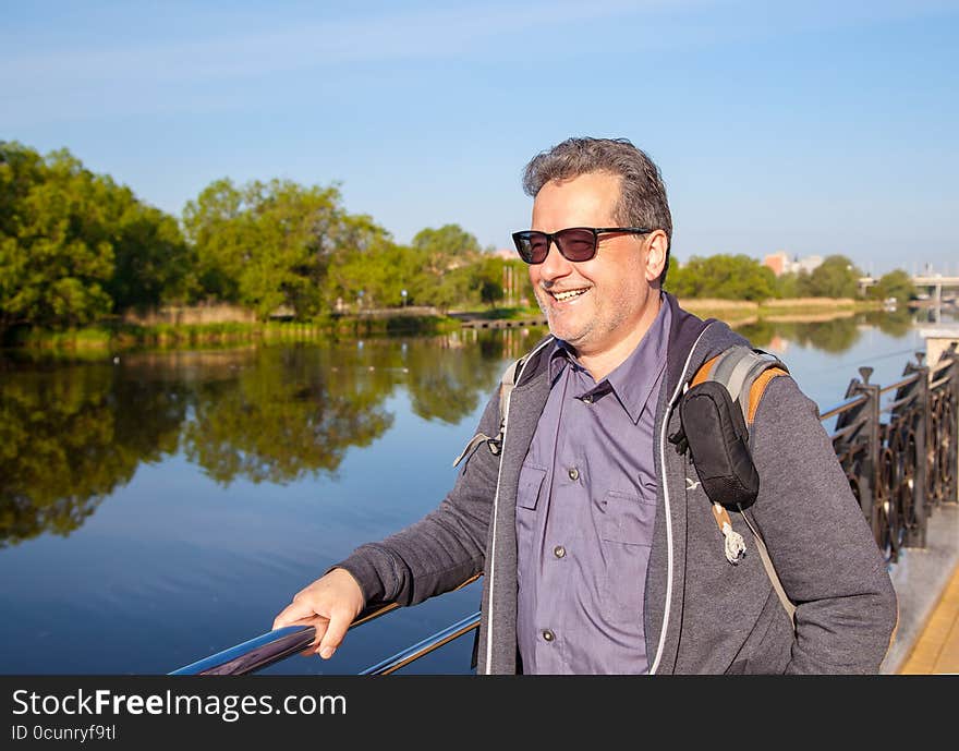 Elderly man with glasses walking along the promenade