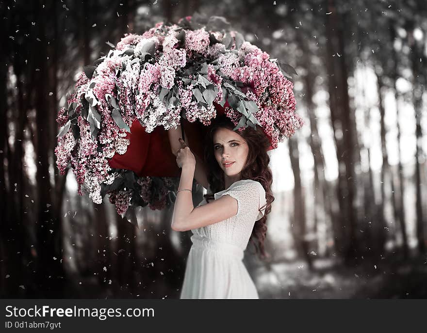 Young girl in soft light style color standing in lilac flowers. umbrella. Beautiful fashion make up. Sun shadow on face. Young girl in soft light style color standing in lilac flowers. umbrella. Beautiful fashion make up. Sun shadow on face