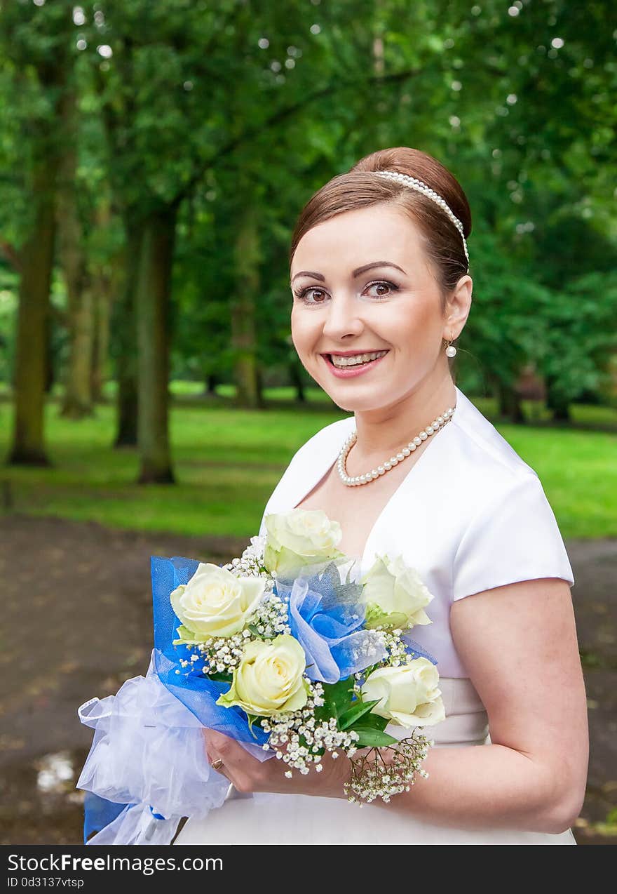 Young Smiling Bride With A Bouquet Of Roses