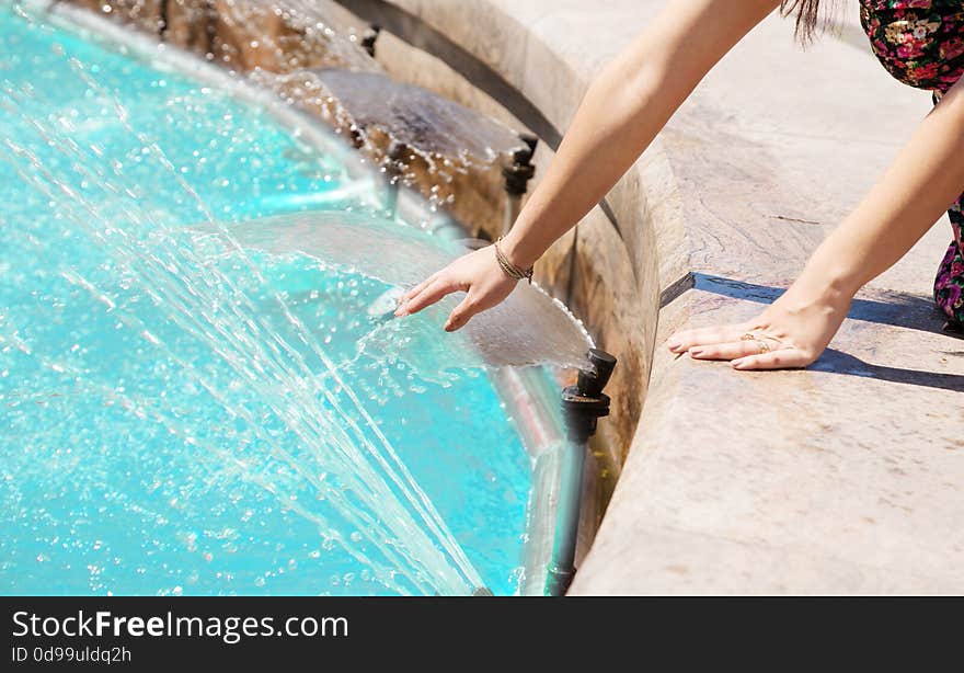 Girl Put Her Hand In A Fountain