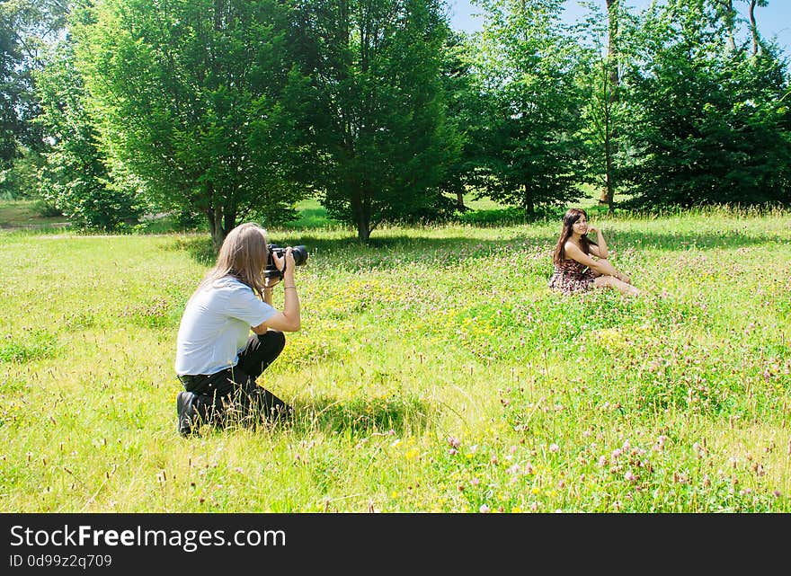 Photographer Takes A Woman Sitting On The Grass In The Park