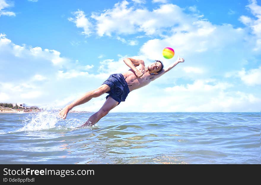 Boy playing ball in the sea