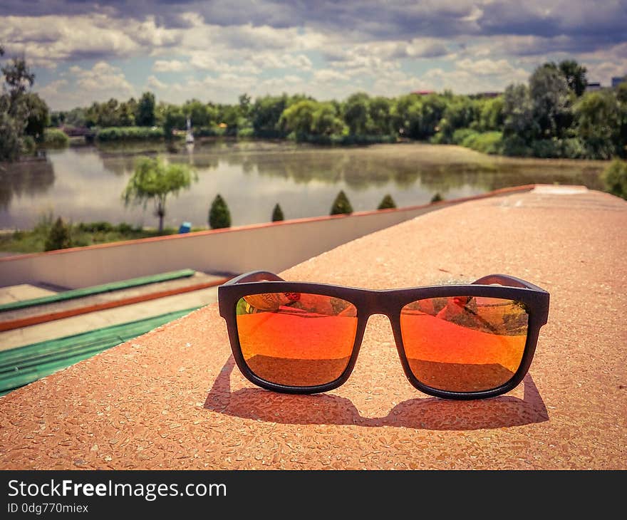 Picture with summer fashion orange polarized eyewhear and beautiful blue clouds after storm. Picture with summer fashion orange polarized eyewhear and beautiful blue clouds after storm