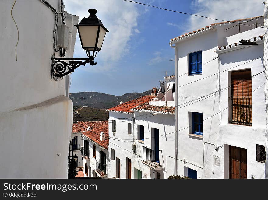 Beautiful and charming with its narrow streets and footpaths white village Frigiliana, close to Nerja - holiday destination of Costa del Sol, about 40 miles from Malaga. view from narrow street. Beautiful and charming with its narrow streets and footpaths white village Frigiliana, close to Nerja - holiday destination of Costa del Sol, about 40 miles from Malaga. view from narrow street.