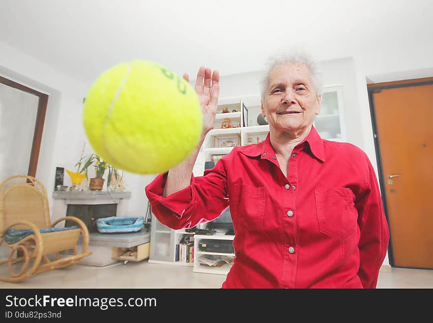 Pet s prospective. Grandmother paly wits a tennis ball.