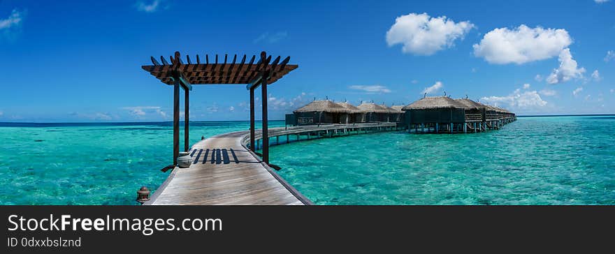 Amazing beautiful tropical beach panorama with wooden ocean water villas at Maldives