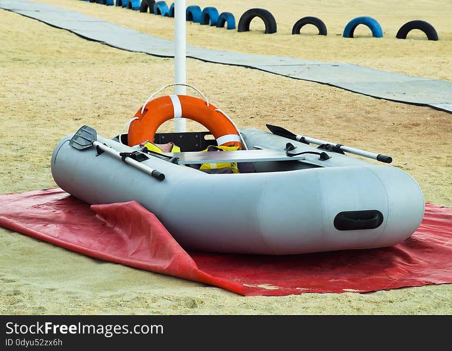 Inflatable Rescue Boat. Gray inflatable boat on the beach in the sand.