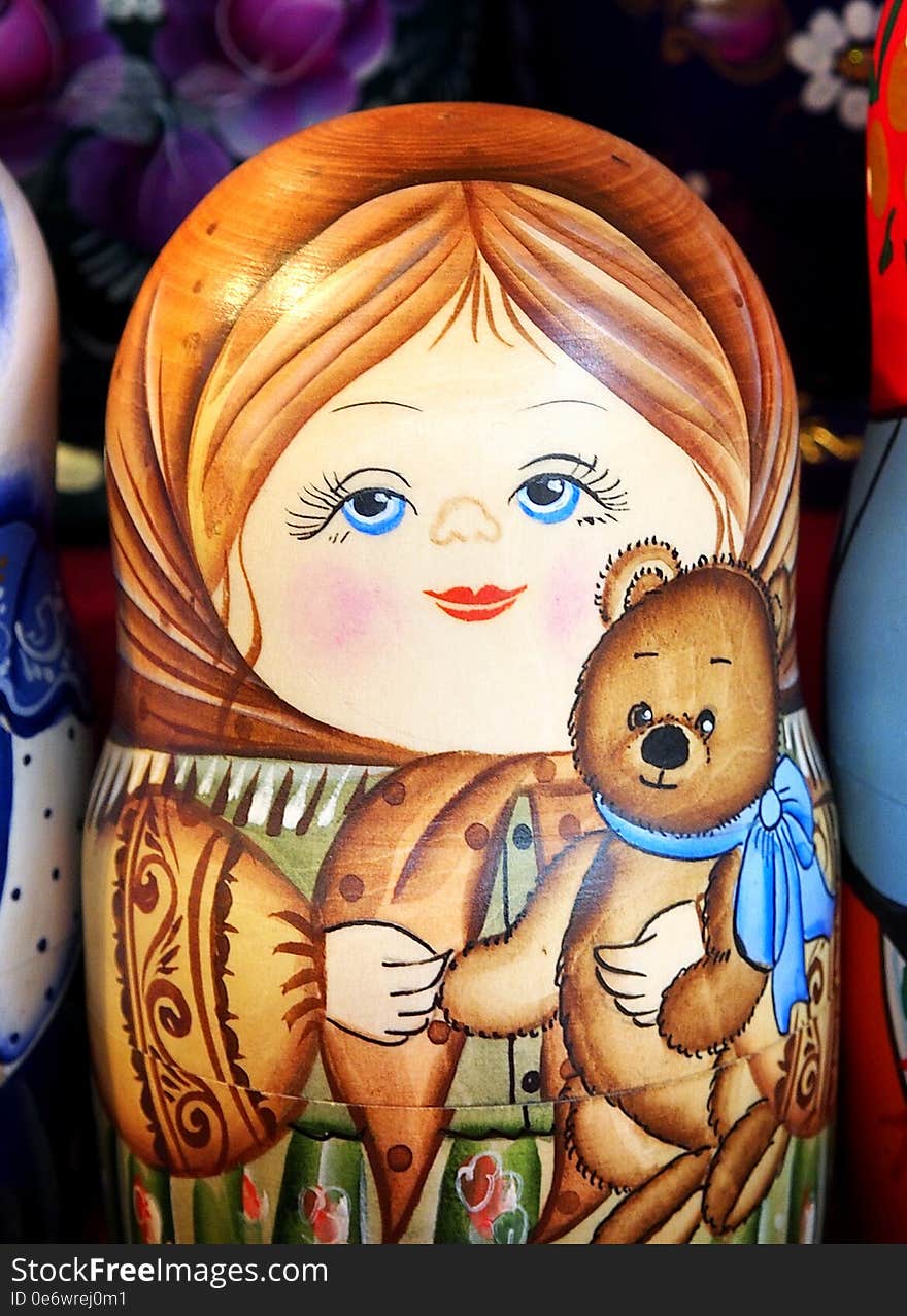 Matrioska representing a young girl with a toy bear. On sale in a christmas street market. Matrioska representing a young girl with a toy bear. On sale in a christmas street market.