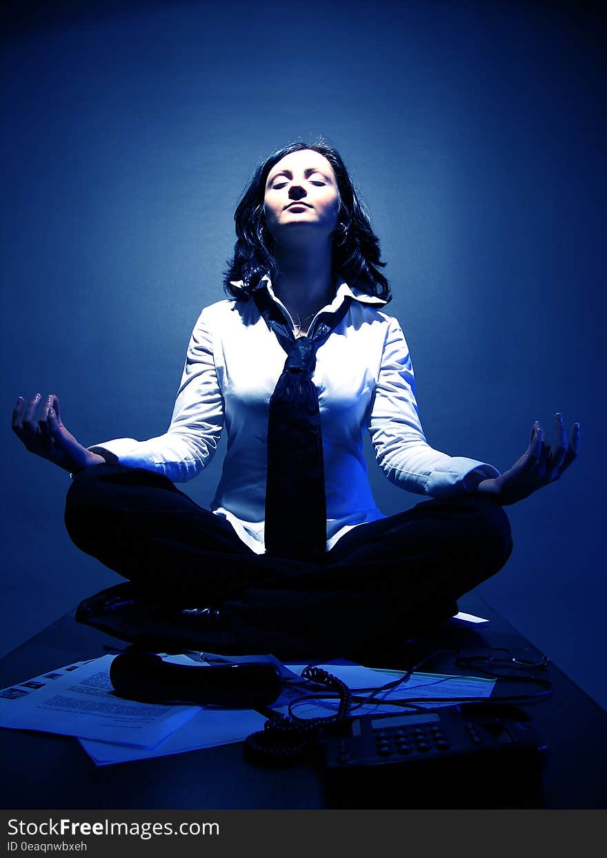 An attractive businesswoman in lotus position, invoking good karma over the business. An attractive businesswoman in lotus position, invoking good karma over the business.